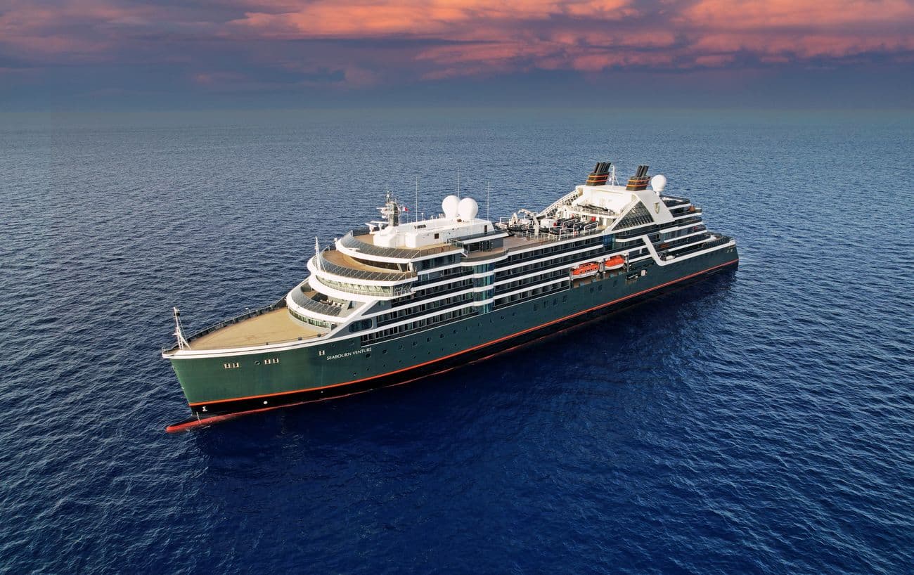 Seabourn Cruise Line expedition ship Seabourn Venture at sea beneath a colorful evening sky