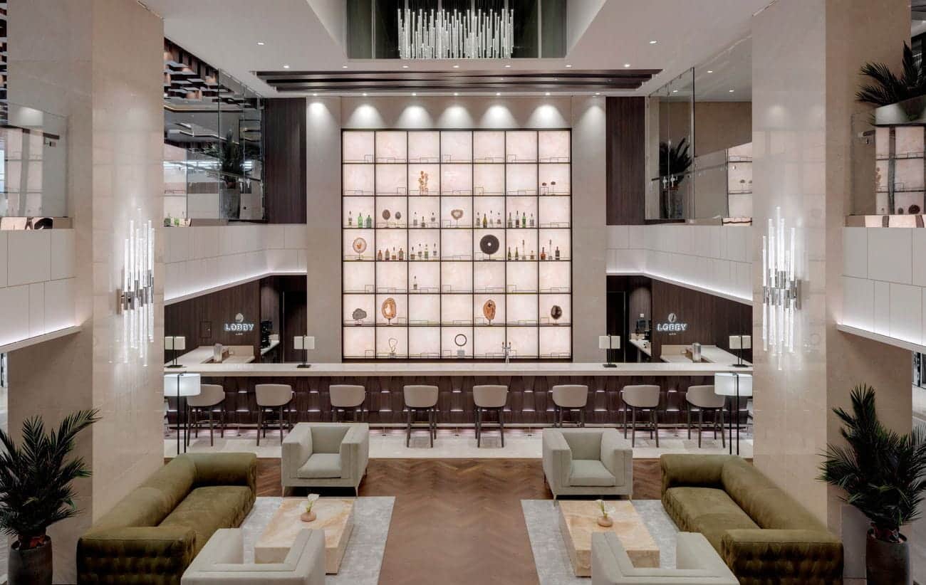 Contemporary ship lobby with central bar, lounge seating and illuminated shelving