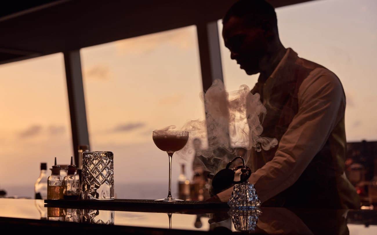 Bartender preparing a smoked cocktail at Malt Whisky Bar