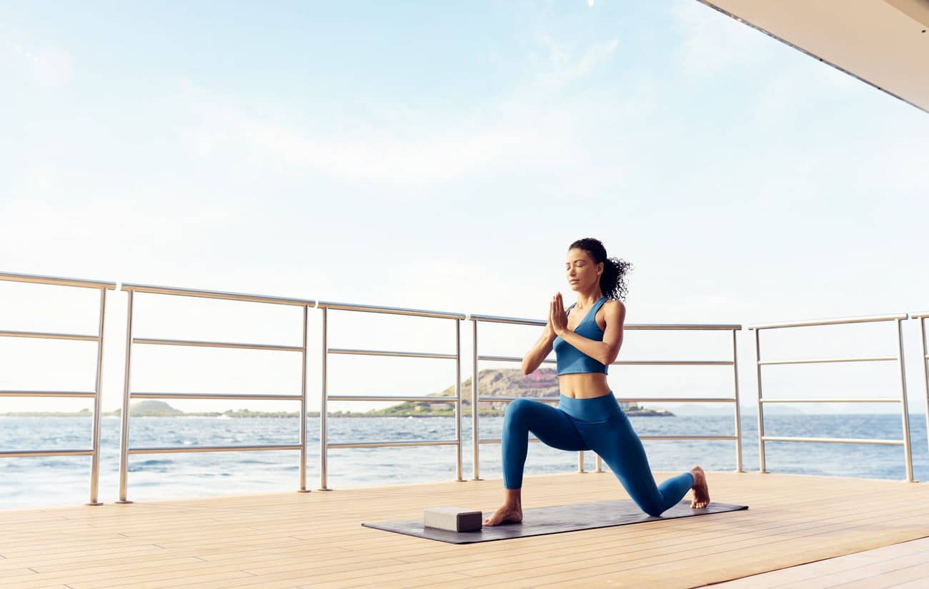Guest practicing yoga on an outdoor yacht deck
