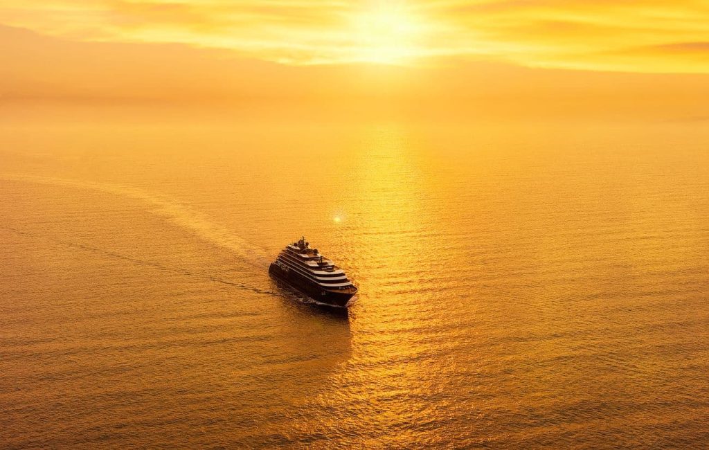 Evrima approaching Valletta across calm Mediterranean waters at golden hour