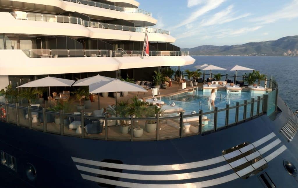 Luminara’s Aft Beach House pool frames the yacht cruise experience with coastal views