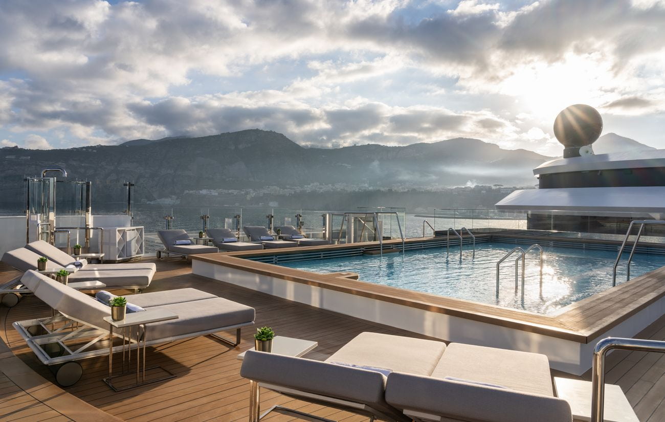 Deck 10 pool surrounded by loungers overlooking the coast