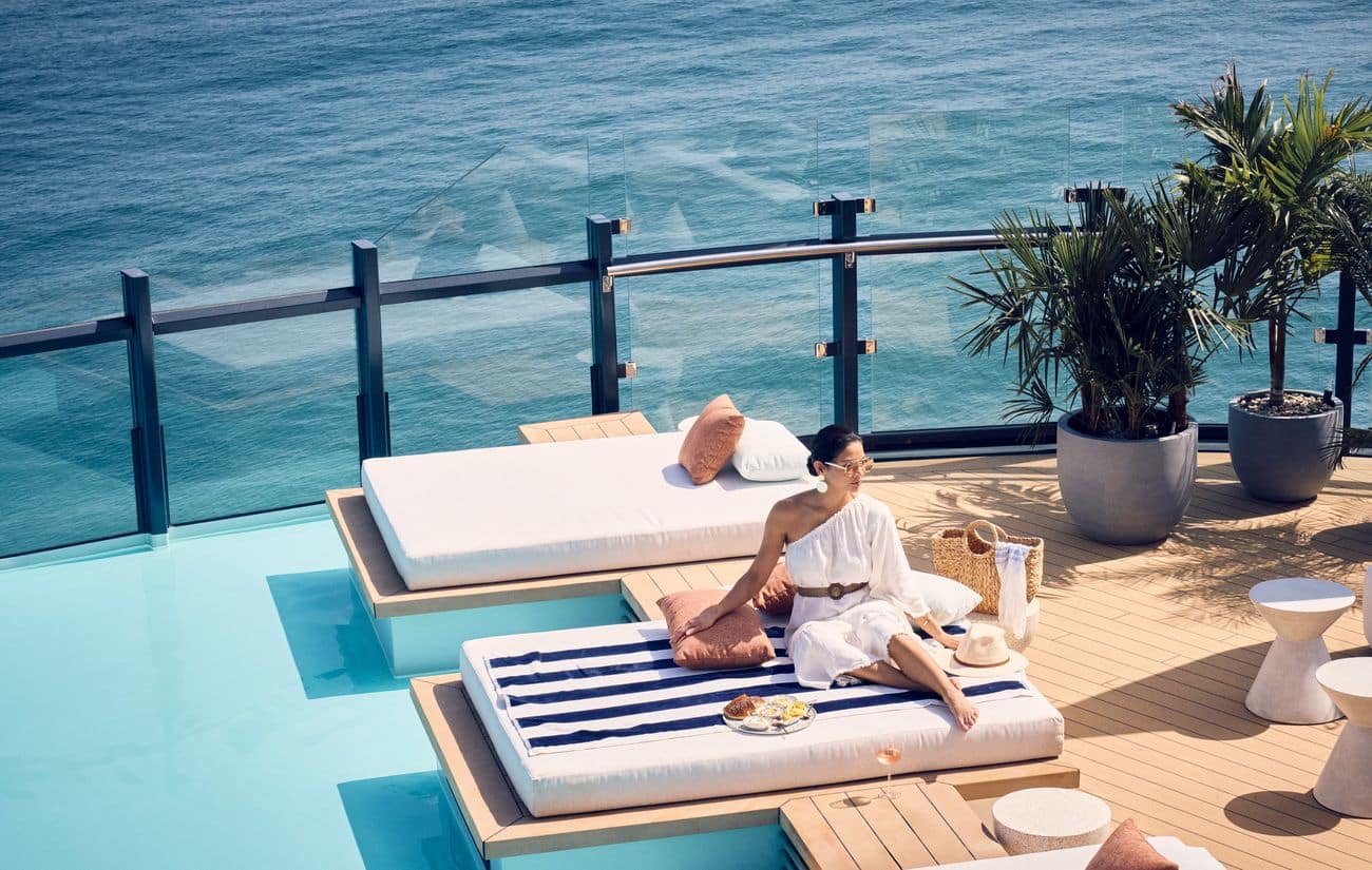 Luminara guest relaxing beside the Beach House pool overlooking the sea